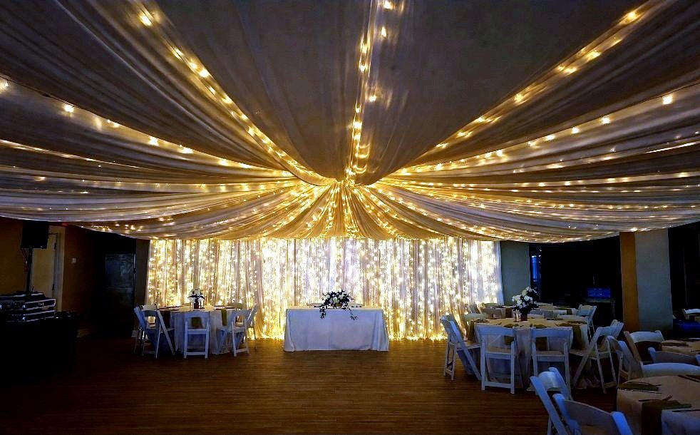 Backdrops — warm ceiling drape with a glowing light-curtain backdrop wall, by Altitude Event Design and Decor, Tampa Bay