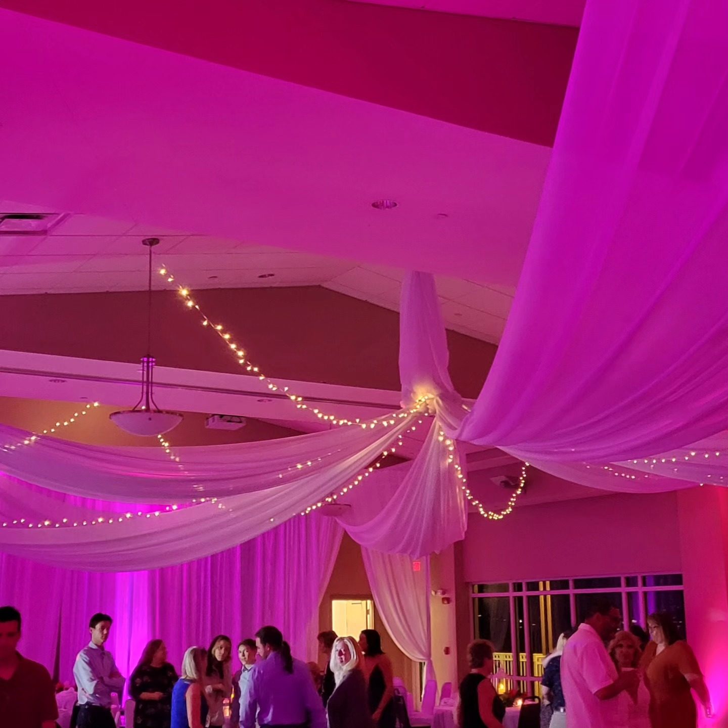 Uplighting — starburst ceiling drape washed in magenta uplight, by Altitude Event Design and Decor, Tampa Bay