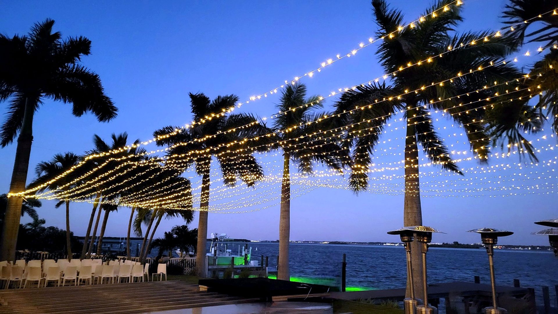 Twinkle and market lights — strung between palm trees over the water at dusk, by Altitude Event Design and Decor, Tampa Bay